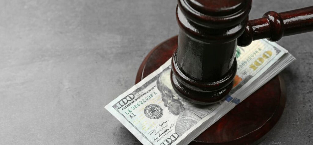 Illustration of a gavel and money to represent a court settlement related to inflated realtors commissions.